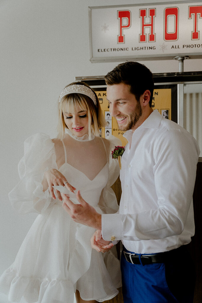 Recently married couple standing at the photo booth inside of sure thing wedding chapel in down town las vegas nevada a popular elopement spot for kitschy destination weddings and adventurous elopements.