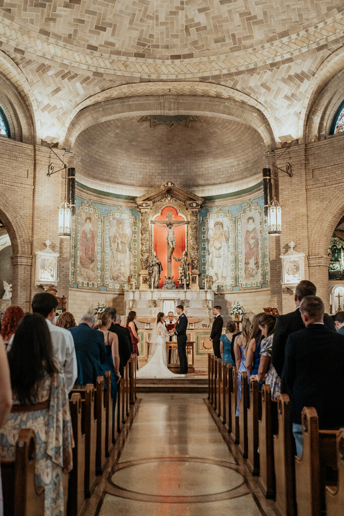 Couple exchanging vows at the Basilica of Saint Lawrence during their Wedding in Asheville, north carolina by Elopement and intimate weddings Photographer and Videographer the combs creative