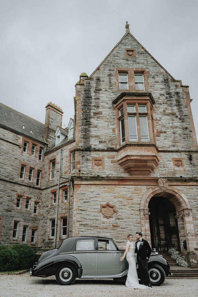 Couple Standing In Front Of Castle Leslie Estate with a Bentley and Horse