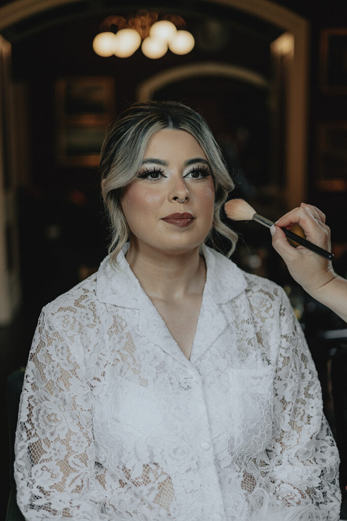 bride getting her makeup done for her wedding ceremony