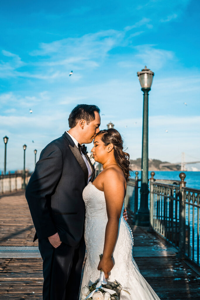 groom kissing the bride on the forehead 