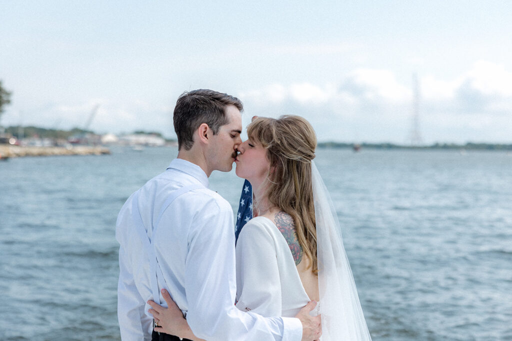 cute couple kissing during their boat ride on their wedding day 