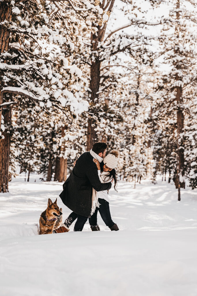 cute couple playing in the snow during their engagement session