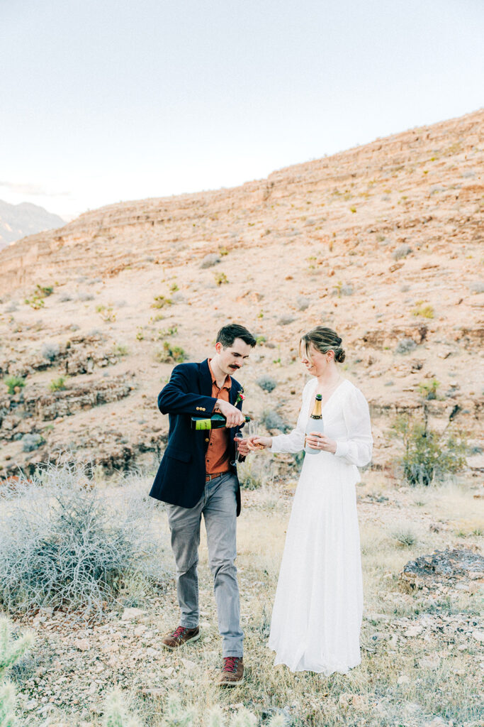 happy couple celebrating their elopement with champagne 