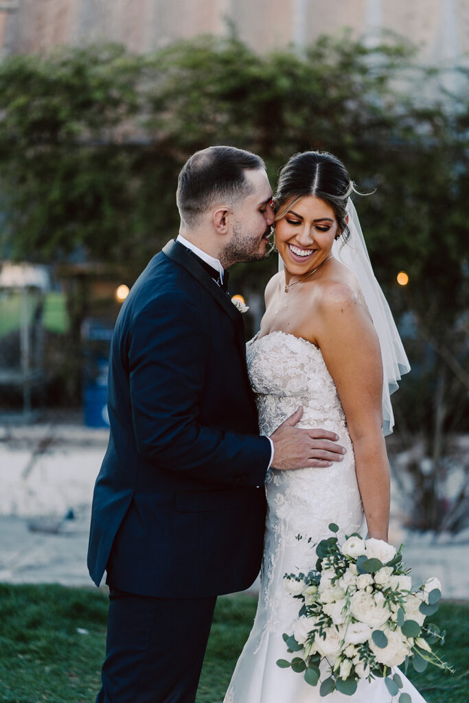 groom kissing the bride on the cheek